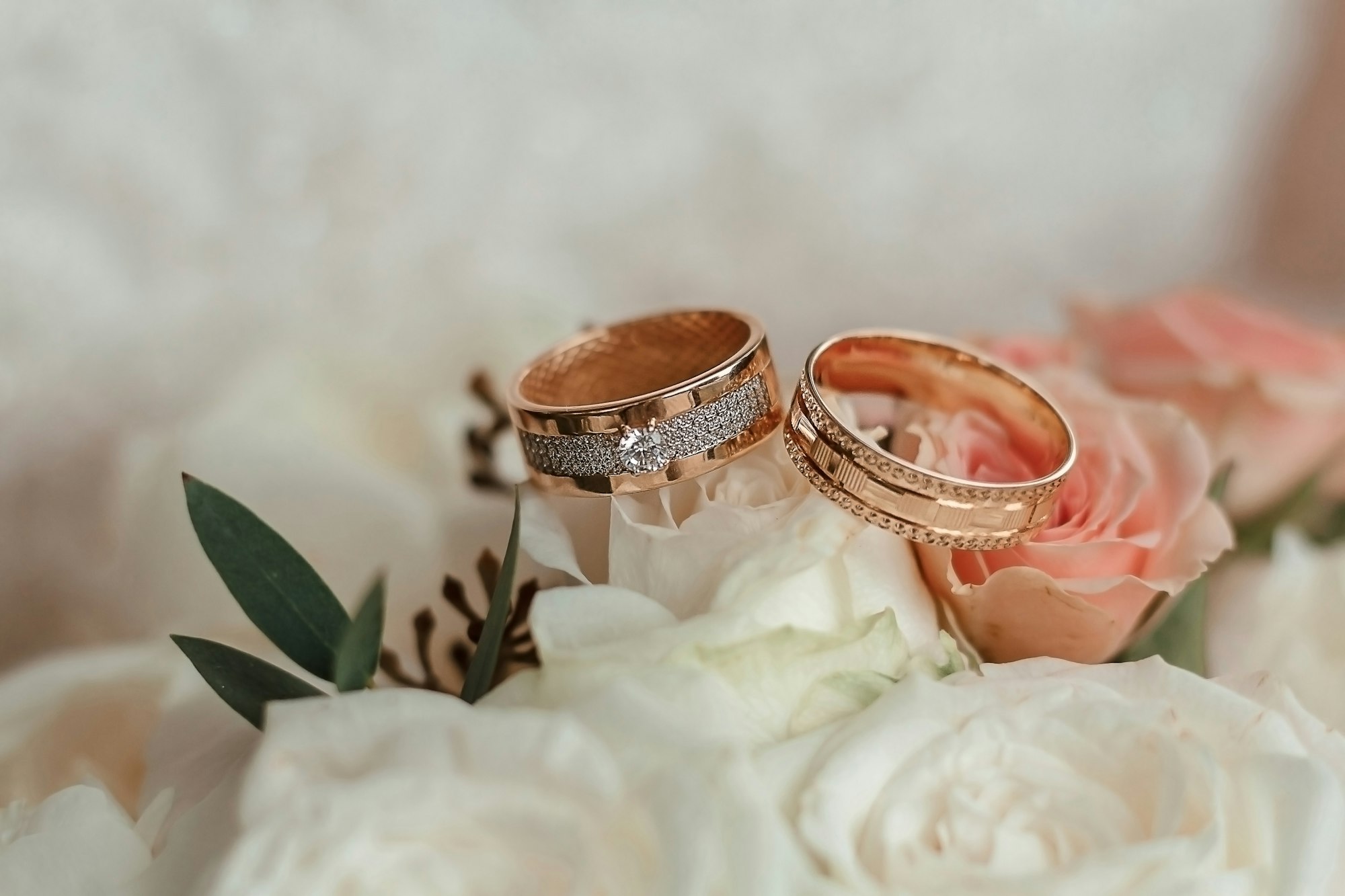 wedding rings close up on bouquet rose.